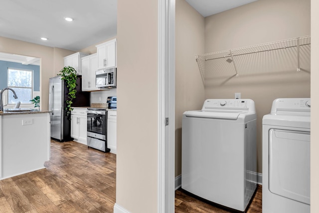 laundry area featuring dark wood-style floors, laundry area, independent washer and dryer, and a sink