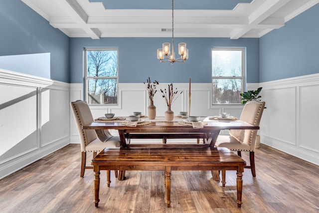 dining space with a decorative wall, beamed ceiling, and a healthy amount of sunlight