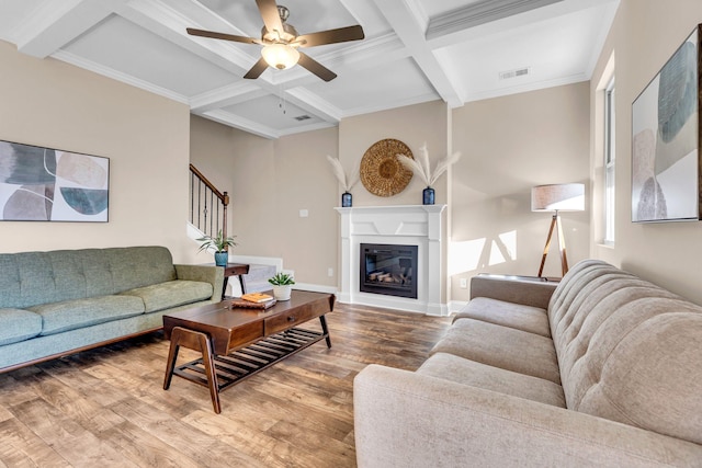 living room with beam ceiling, visible vents, stairway, wood finished floors, and coffered ceiling