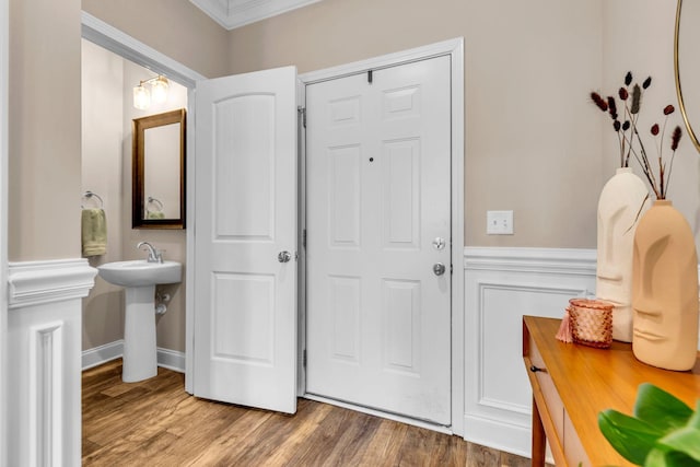 foyer entrance with a wainscoted wall and wood finished floors