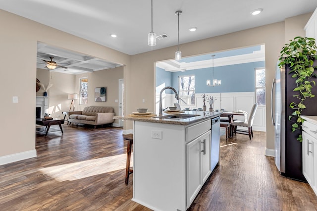 kitchen featuring a fireplace, stainless steel appliances, visible vents, a sink, and coffered ceiling