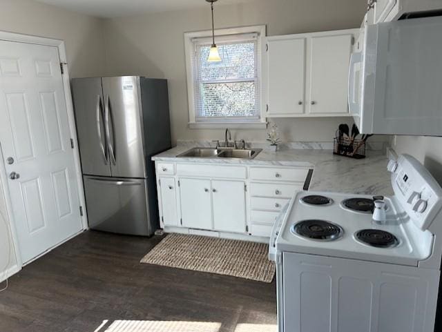 kitchen featuring dark wood-style flooring, hanging light fixtures, white cabinetry, a sink, and white appliances