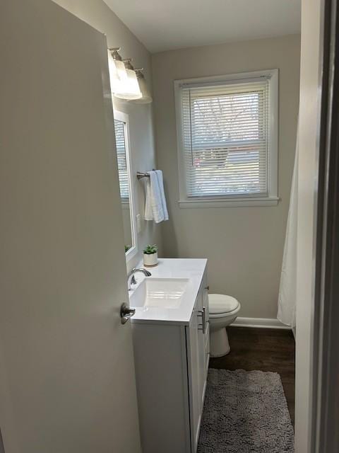 bathroom featuring baseboards, vanity, toilet, and wood finished floors