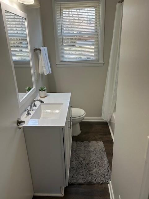 bathroom featuring baseboards, vanity, toilet, and wood finished floors