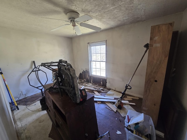 misc room with ceiling fan and a textured ceiling