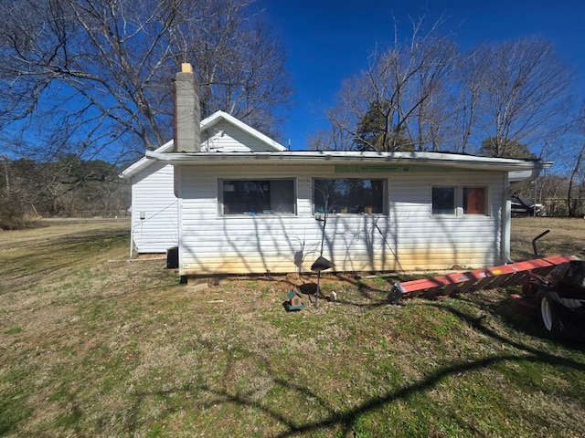 rear view of property with a lawn and a chimney