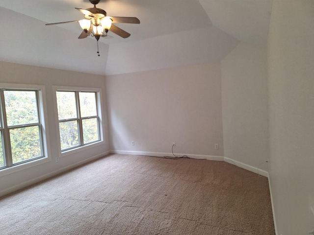 empty room featuring vaulted ceiling, ceiling fan, carpet, and baseboards