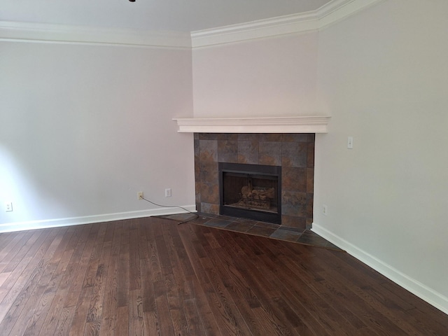 unfurnished living room with ornamental molding, a fireplace, wood finished floors, and baseboards