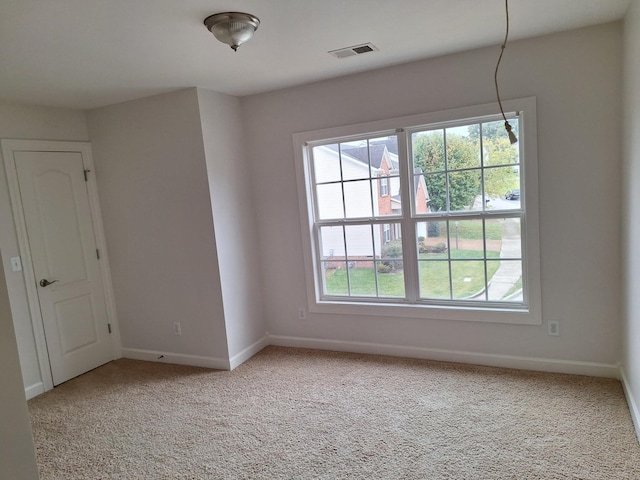 empty room with carpet floors, visible vents, and baseboards