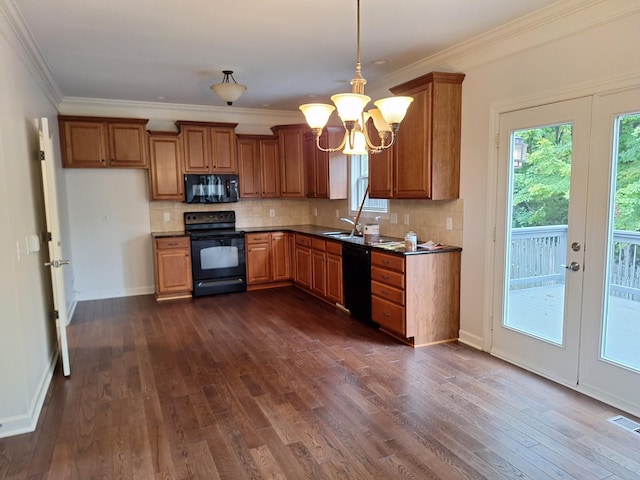 kitchen featuring black appliances, tasteful backsplash, brown cabinetry, and dark wood finished floors