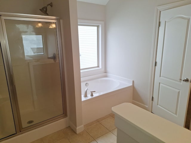 bathroom featuring a stall shower, tile patterned flooring, and a garden tub