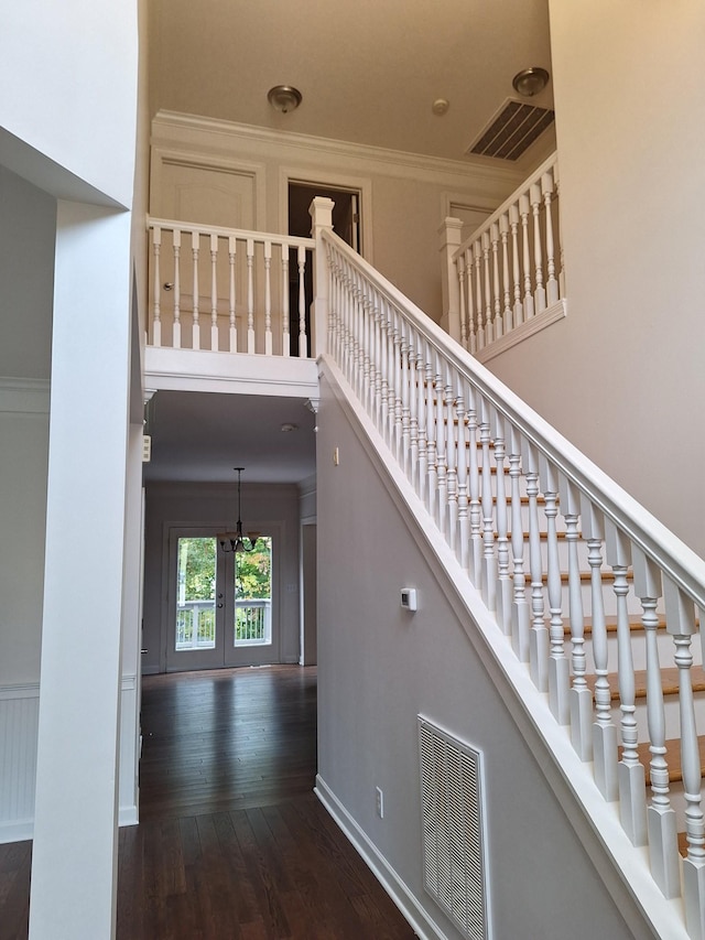 stairs with baseboards, visible vents, hardwood / wood-style floors, a high ceiling, and french doors