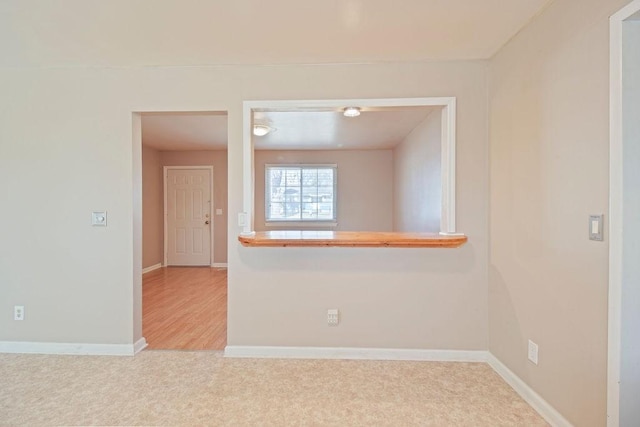 carpeted spare room featuring baseboards