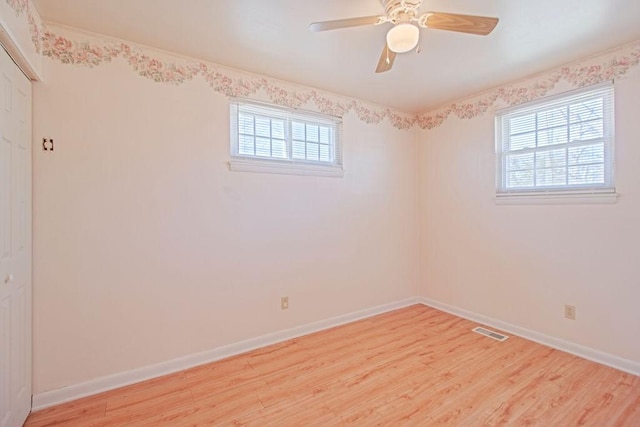 empty room with a wealth of natural light, visible vents, and light wood-style flooring