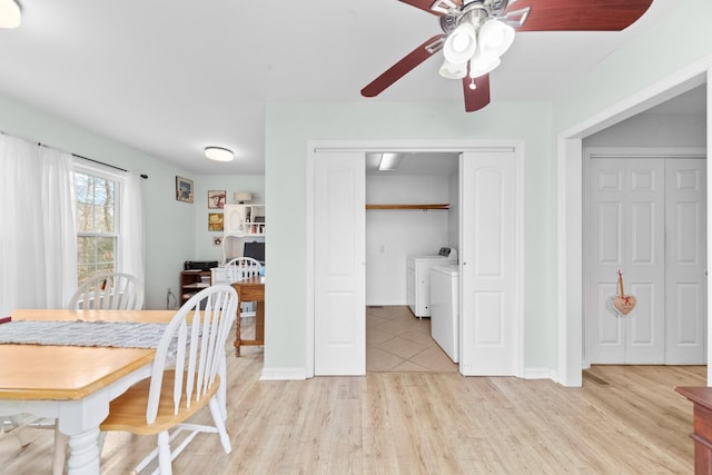 dining area with light wood-type flooring, washing machine and clothes dryer, a ceiling fan, and baseboards