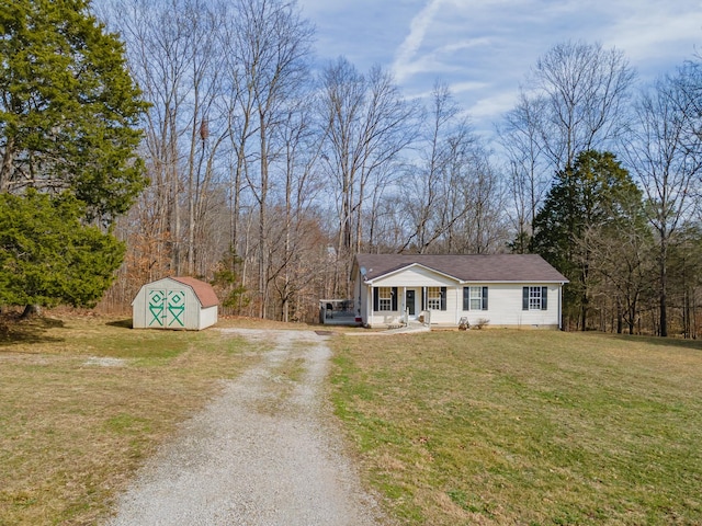 view of front of home featuring a porch, an outdoor structure, a storage shed, driveway, and a front lawn