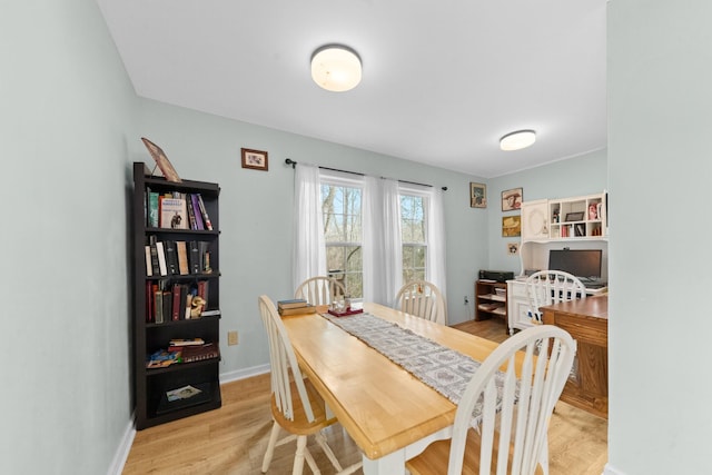 dining space featuring baseboards and light wood-style floors