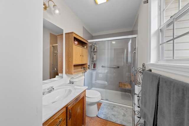 bathroom with toilet, a shower stall, tile patterned flooring, and vanity