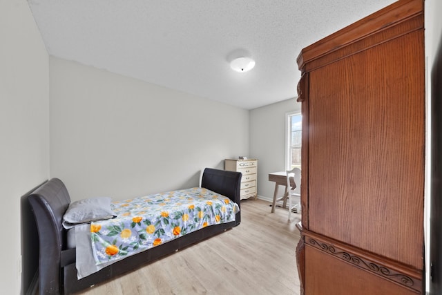 bedroom featuring light wood-type flooring and a textured ceiling