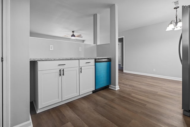 kitchen featuring baseboards, dark wood-type flooring, freestanding refrigerator, and white cabinets