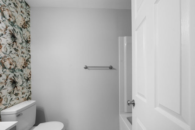 full bathroom with a tub to relax in, vanity, toilet, and wallpapered walls