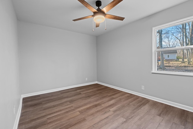 empty room featuring a ceiling fan, baseboards, and wood finished floors