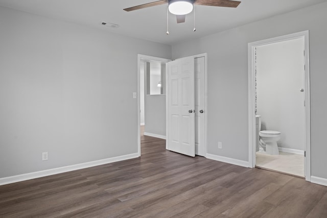 unfurnished bedroom featuring visible vents, connected bathroom, baseboards, and wood finished floors