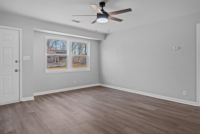 unfurnished room with dark wood-type flooring, visible vents, ceiling fan, and baseboards