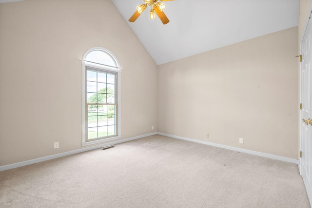 spare room with visible vents, a ceiling fan, light carpet, high vaulted ceiling, and baseboards