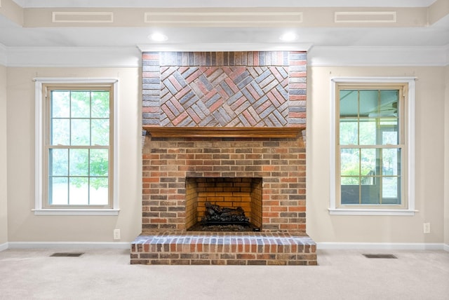 unfurnished living room featuring carpet, a healthy amount of sunlight, and visible vents