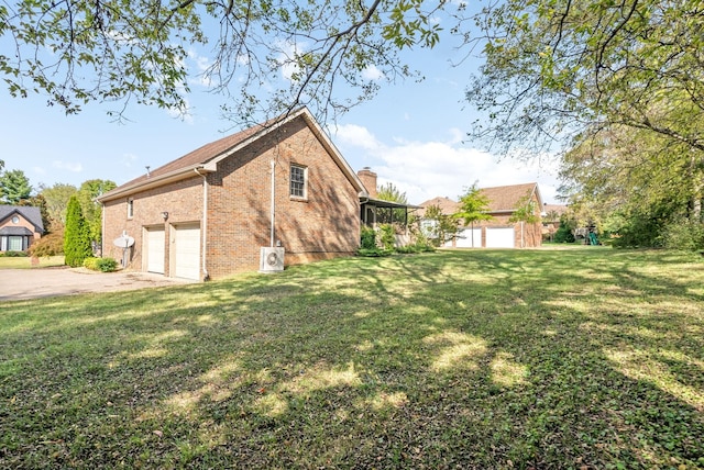 view of home's exterior with a garage, brick siding, concrete driveway, a yard, and a chimney