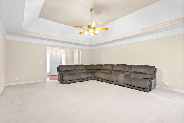 carpeted living area featuring visible vents, baseboards, a raised ceiling, ceiling fan, and crown molding