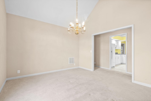 spare room featuring high vaulted ceiling, light carpet, visible vents, baseboards, and an inviting chandelier