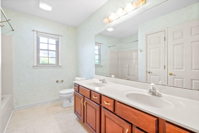 full bath with baseboards, a sink, toilet, and double vanity