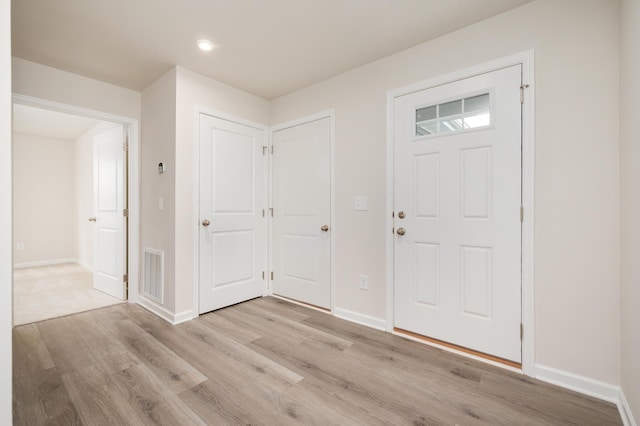 entryway featuring light wood-type flooring, visible vents, and baseboards