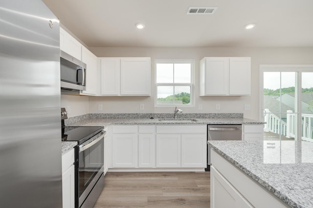 kitchen with visible vents, plenty of natural light, stainless steel appliances, and a sink