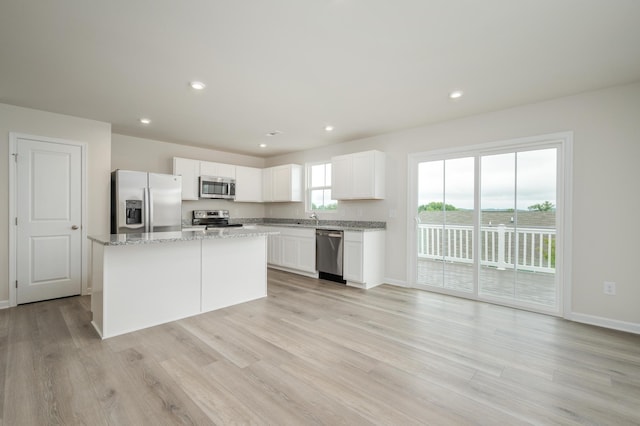 kitchen featuring a kitchen island, light wood-type flooring, recessed lighting, appliances with stainless steel finishes, and white cabinets