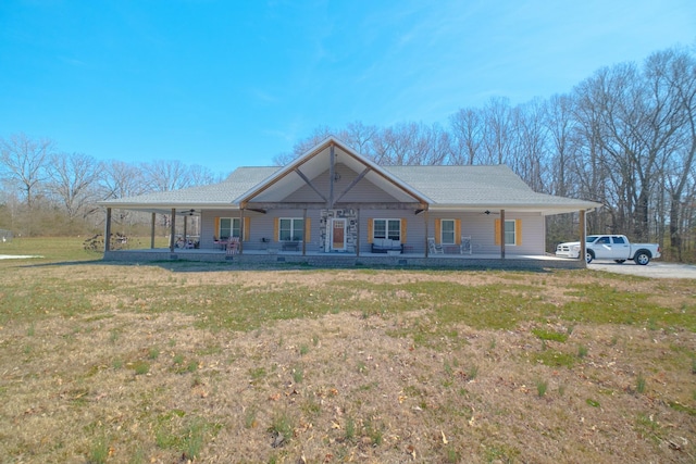 view of front facade featuring a porch, a ceiling fan, an attached carport, driveway, and a front lawn