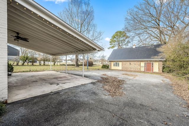 view of vehicle parking featuring aphalt driveway and a ceiling fan