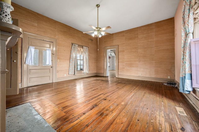 unfurnished room featuring hardwood / wood-style flooring, baseboards, visible vents, and ceiling fan