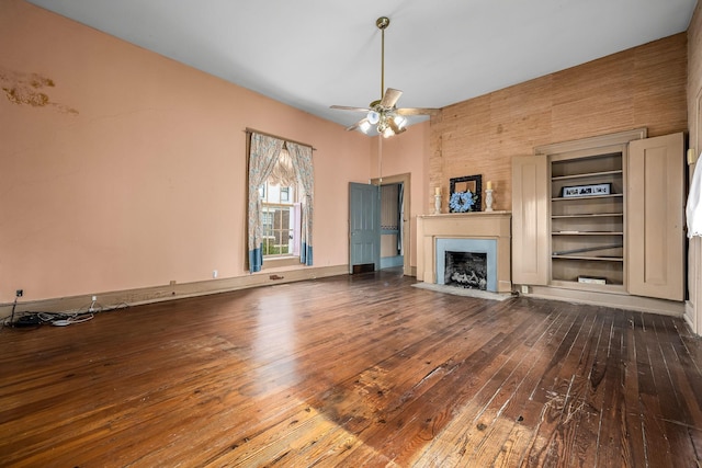 unfurnished living room featuring hardwood / wood-style flooring, a fireplace with flush hearth, baseboards, and ceiling fan