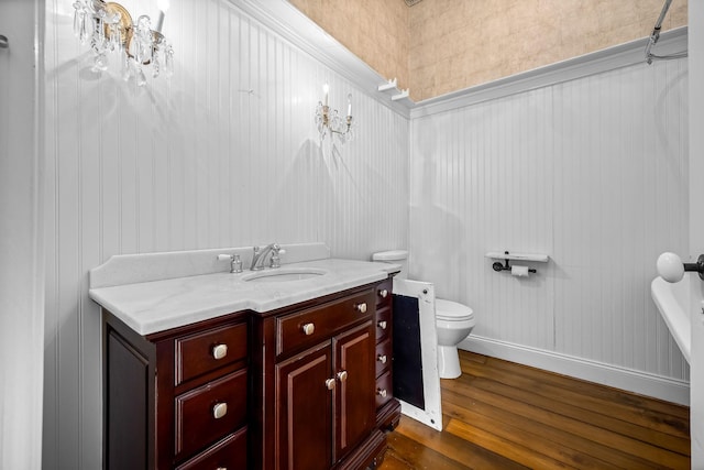 bathroom featuring vanity, wood finished floors, toilet, and baseboards