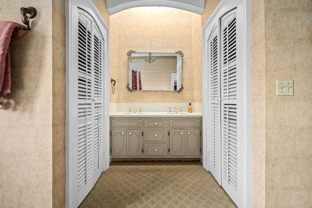 bathroom featuring a closet, a sink, and double vanity