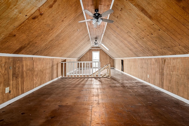 bonus room featuring wood walls, baseboards, vaulted ceiling, and a ceiling fan