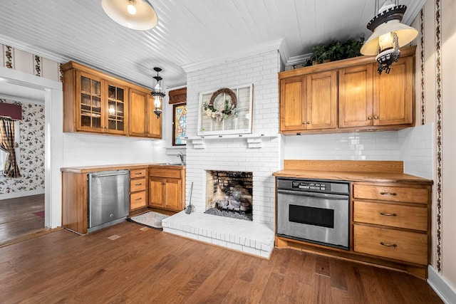 kitchen featuring brown cabinets, decorative light fixtures, dark wood-type flooring, stainless steel oven, and fridge