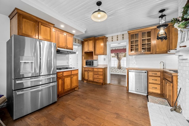 kitchen with dark wood-style floors, stainless steel appliances, brown cabinetry, and under cabinet range hood