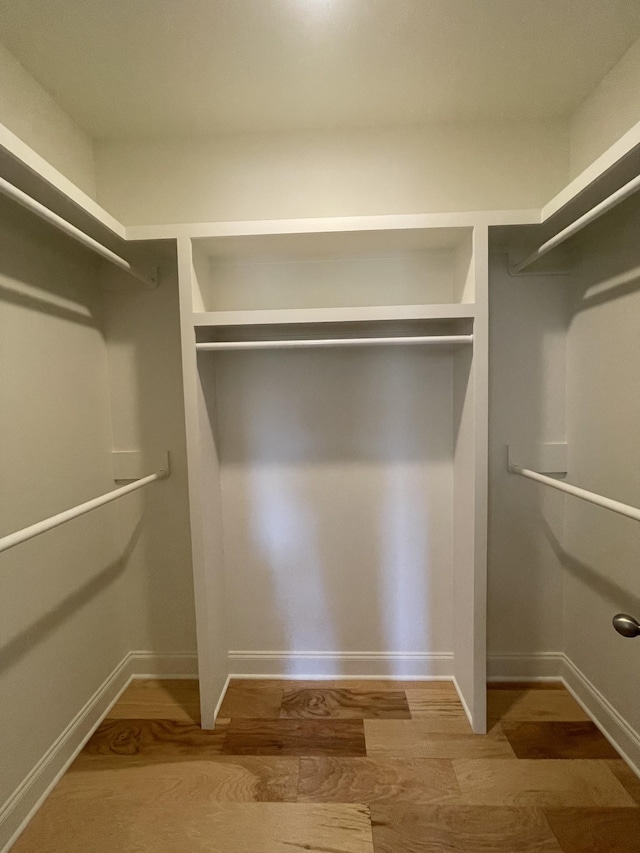 walk in closet with wood finished floors