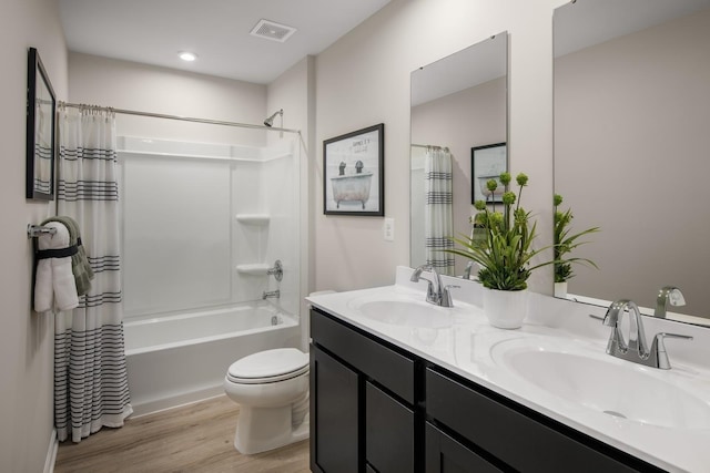 bathroom with shower / bathtub combination with curtain, wood finished floors, visible vents, and a sink