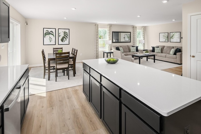 kitchen with light wood finished floors, recessed lighting, light countertops, dishwasher, and dark cabinets