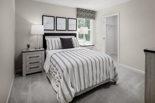 carpeted bedroom featuring a walk in closet, baseboards, and a closet